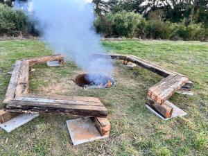 a pile of wood burning in a field with smoke at Refugio del Sur, Escapada in Llanquihue