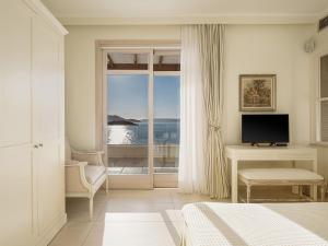 a bedroom with a window with a view of the ocean at SK Place Luxury Seafront Villas Chania in Almyrida