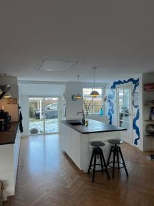 a kitchen with a island with two bar stools at Large townhouse Odense in Odense