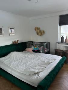 a bed with a green headboard in a bedroom at Large townhouse Odense in Odense