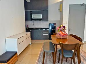 a kitchen with a table and chairs and a refrigerator at Almyra cozy condo in Kajang