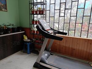 a room with a treadmill in front of a window at Hotel Paryatak in Namchi