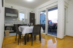 a kitchen and dining room with a table and chairs at Summer Breeze Pool Apartments in Novalja