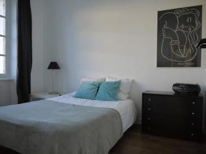 a bedroom with a bed with blue pillows and a dresser at Maison Ville - Plage - Concarneau in Concarneau