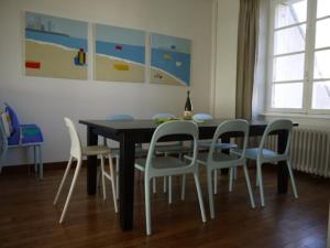 a dining room table with chairs and a bottle of wine at Maison Ville - Plage - Concarneau in Concarneau