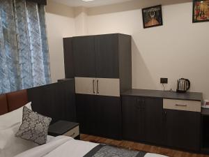 a bedroom with a bed and a black cabinet at Hotel Paryatak in Namchi