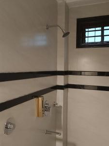 a bathroom with a shower with black and white stripes at Hotel Paryatak in Namchi +26 photos