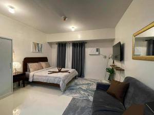 a bedroom with a bed and a couch at New Cozy Studio Apartment in Cebu City