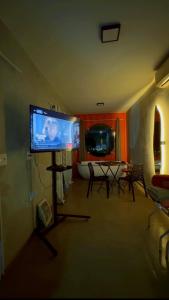 a living room with a tv and a table and chairs at Amsterdam Lofts Deluxe in Poços de Caldas