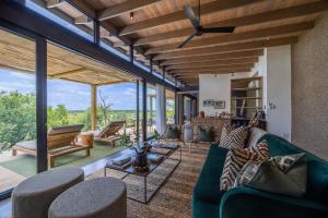 a living room with a green couch and chairs at Klaserie Drift Misava in Klaserie Private Nature Reserve