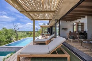 an outdoor deck with chairs and a swimming pool at Klaserie Drift Misava in Klaserie Private Nature Reserve