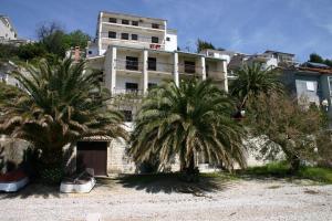 two palm trees in front of a building at 230 MESTRO in Stanići +39 photos