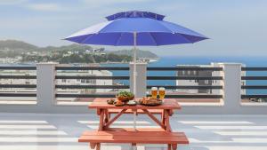 a picnic table with a blue umbrella on a balcony at Samcheok Jisu Pension in Samcheok +2 photos