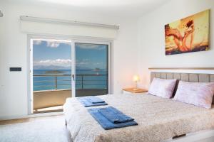 a bedroom with a bed with a view of the ocean at Villa Azure Heaven in Turgutreis +42 photos