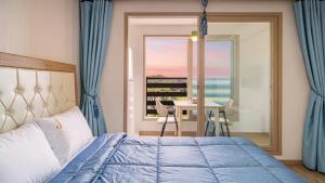a bedroom with a bed and a view of the ocean at Yeongheungdo J Pension in Incheon