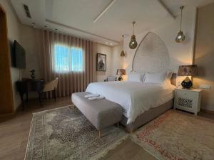 a bedroom with a large white bed and a desk at Palais Elya in Rabat +82 photos