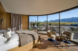a bedroom with a bed and a large window at Sonnenalp Resort in Ofterschwang