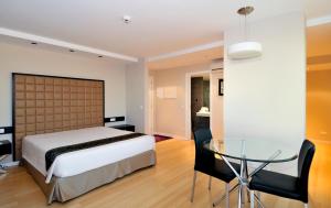 Schlafzimmer mit einem Bett und einem Glastisch in der Unterkunft Sweet Atlantic Hotel & Spa in Figueira da Foz