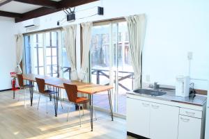 a kitchen with a table and chairs and a large window at 彩の宿月屋 in Yamanakako