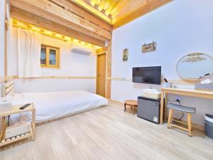 a bedroom with a bed and a desk and a tv at 나들한옥 한옥스테이 in Gyeongju