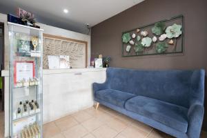 a blue couch in a room with a pharmacy at RedDoorz Plus at Hotel Ulin Samarinda in Samarinda