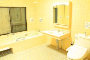 a yellow tiled bathroom with a sink and a toilet at 彩の宿月屋 in Yamanakako +42 photos