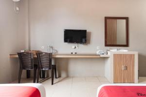 a room with a desk with a sink and a mirror at RedDoorz Plus at Hotel Ulin Samarinda in Samarinda