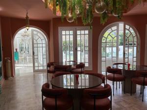 a restaurant with tables and chairs and windows at Palais Elya in Rabat