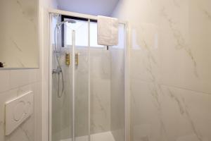 a bathroom with a shower with a glass door at Residence Concordia in Gorizia +41 photos