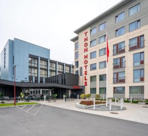 a hotel building with a flag in front of it at Thon Hotel Brønnøysund in Brønnøysund