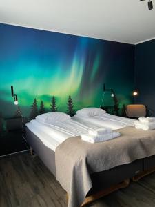 a bedroom with a large bed with the northern lights at Hotell Amber & Naran in Luleå