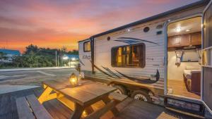 an rv parked with a wooden table in front of it at Goseong Jjun Camping Pension in Goseong +2 photos