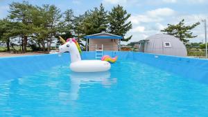 a inflatable unicorn float in a swimming pool at Goseong Jjun Camping Pension in Goseong