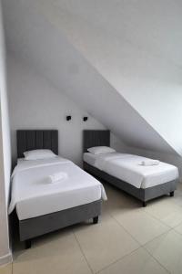 two beds in a room with a attic at Apartamenty Odrodzenia 11 in Szczytno