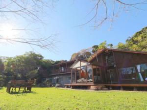 a house with a picnic table in a field at La villetta 白浜 in Minamiboso