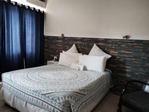 a bedroom with a bed with a brick wall at Concord Christian Guesthouse in Durban