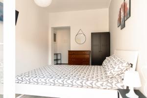 a white bedroom with a bed and a dresser at Tenuta Mastro in Sulmona