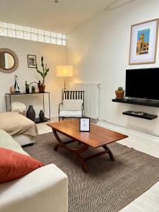 a living room with a coffee table and a tv at L'escale Barbieux in Croix
