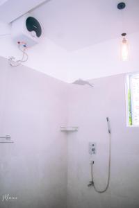 a bathroom with a shower with a light on the wall at Coco Leaf Apartment with Private Pool Near the Beach in Hikkaduwa +12 photos