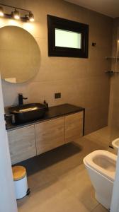 a bathroom with a sink and a mirror and a toilet at Amanecer del lago in San Carlos de Bariloche