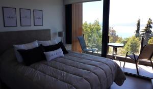 a bedroom with a large bed and a large window at Amanecer del lago in San Carlos de Bariloche
