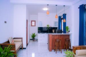 a living room with a kitchen and a bar with stools at Coco Leaf Apartment with Private Pool Near the Beach in Hikkaduwa