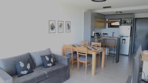 a living room with a couch and a table and a kitchen at Amanecer del lago in San Carlos de Bariloche