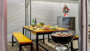 a table with food on it with a grill at Samcheok Lamer Pension in Samcheok