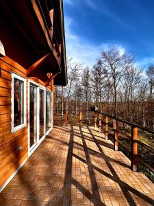 a wooden porch of a house with trees in the background at Tokachi Mikage forest villa in Mikage
