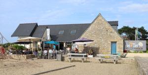 a building with a group of people sitting outside of it at Seasonova Camping Les 7 iles in Trélévern