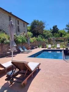 a pool with two lounge chairs and a umbrella at La Luna Buona in Vesime