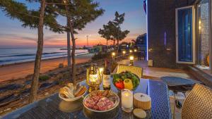 a table with a bowl of food on top of a beach at Pohang Playbeach Poolvilla in Pohang