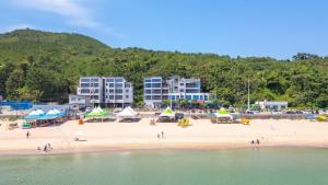 a beach with umbrellas and people on the sand at Pohang Playbeach Poolvilla in Pohang