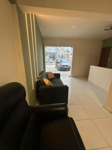 a living room with a couch and a view of a street at Pousada Oxente Carioca in João Pessoa